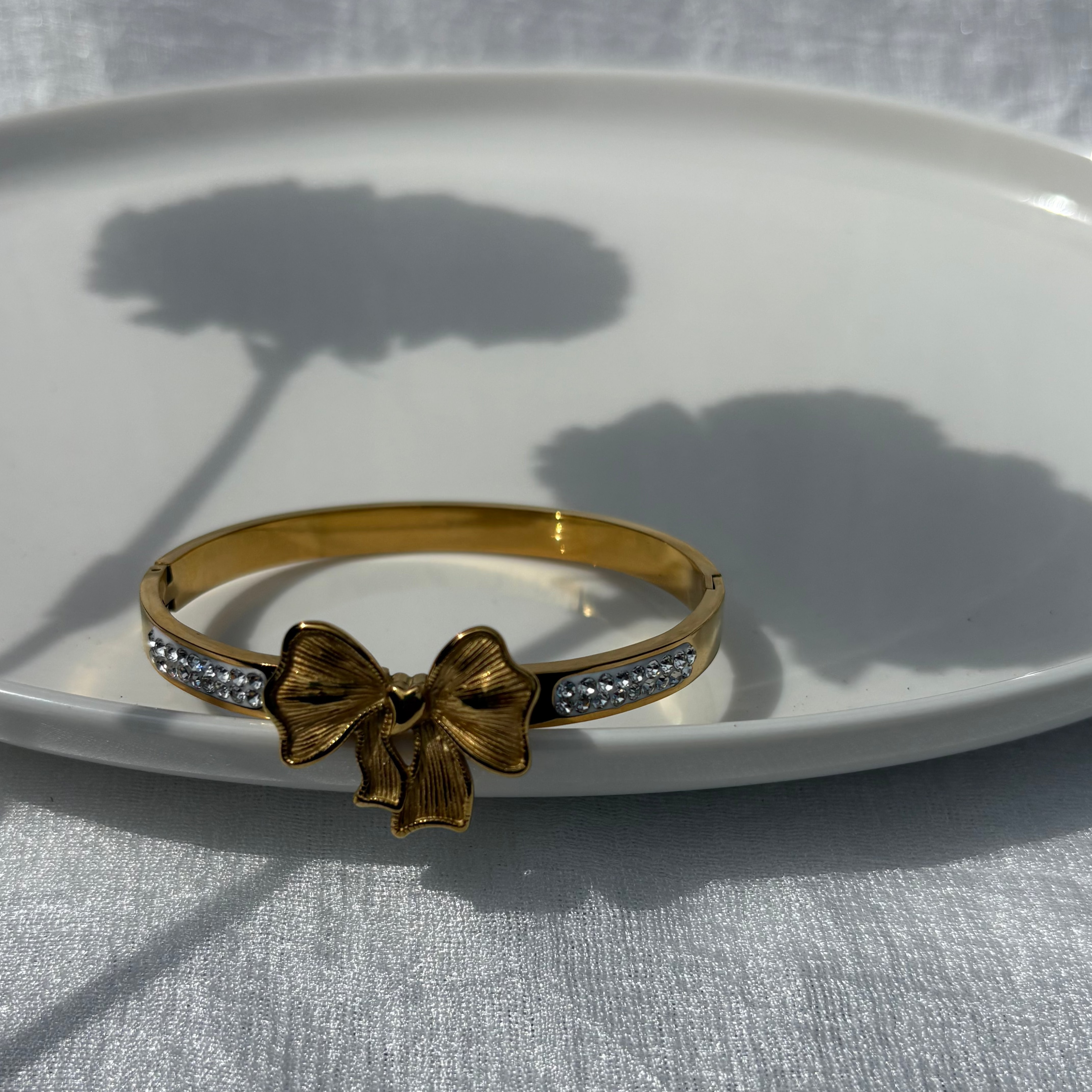 Bow charm bracelet with cubic zirconia