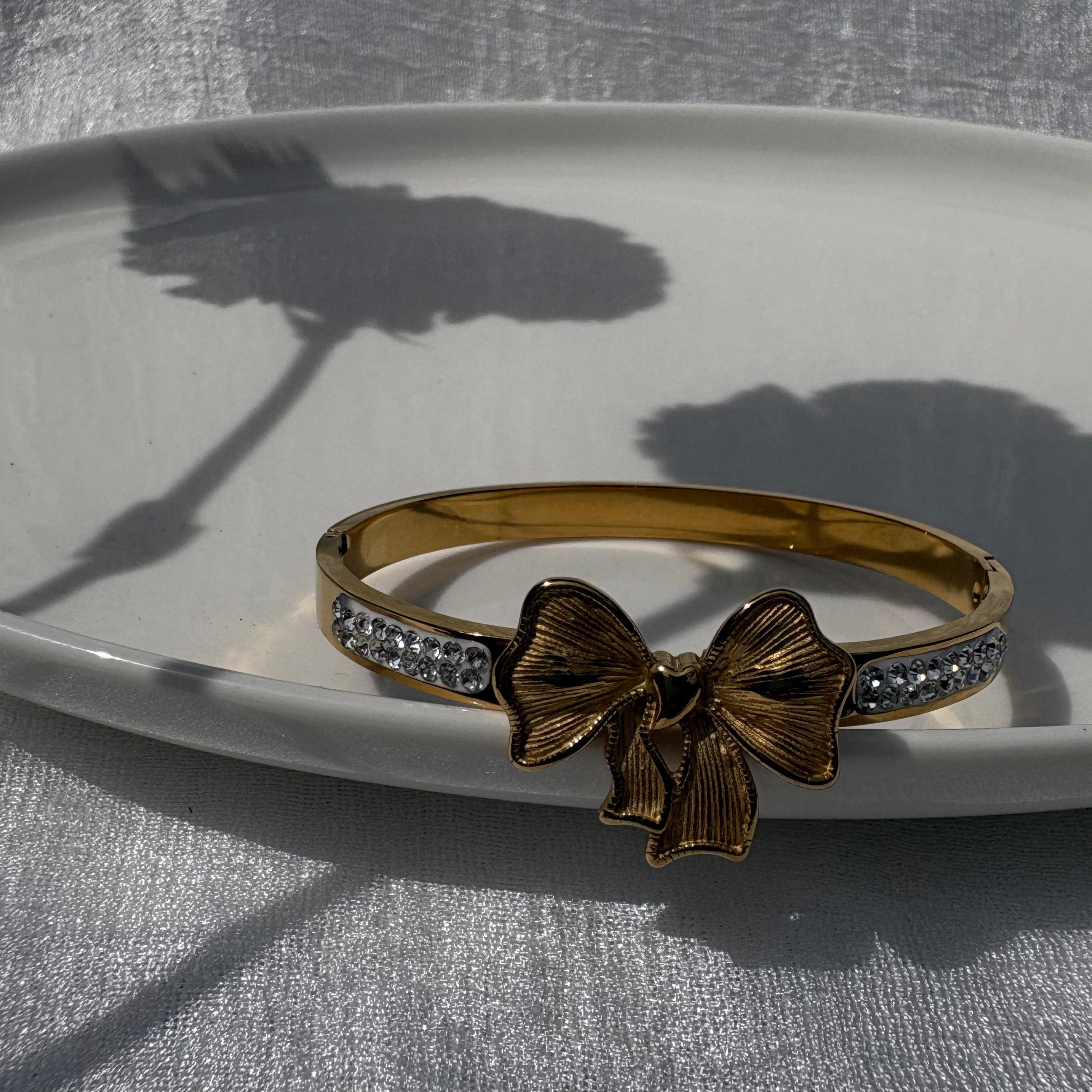 Bow charm bracelet with cubic zirconia